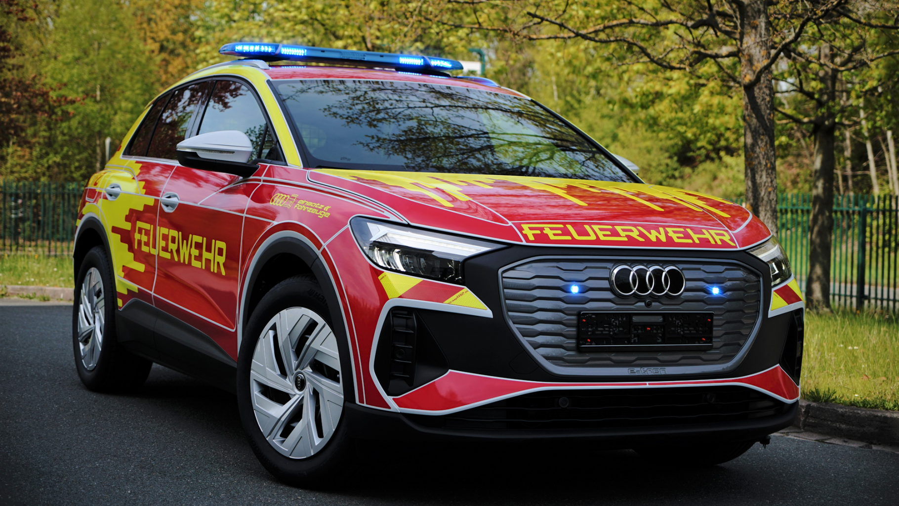 audi_son0753316_9_587968016 Ein Feuerwehrauto steht vor einer Gruppe von Bäumen.