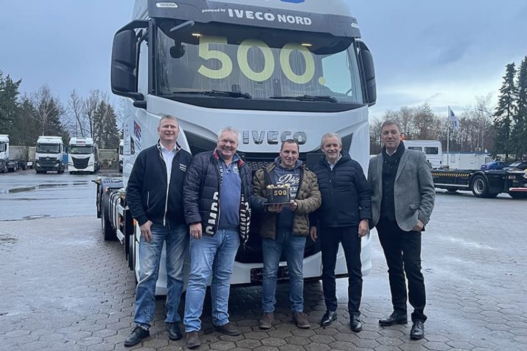 Das Bild zeigt fünf weiße Männer, die bei kühleren Temperaturen vor einem Iveco S-Way Truck stehen. Auf der Windschutzscheibe ist die zahl 500 angebracht.