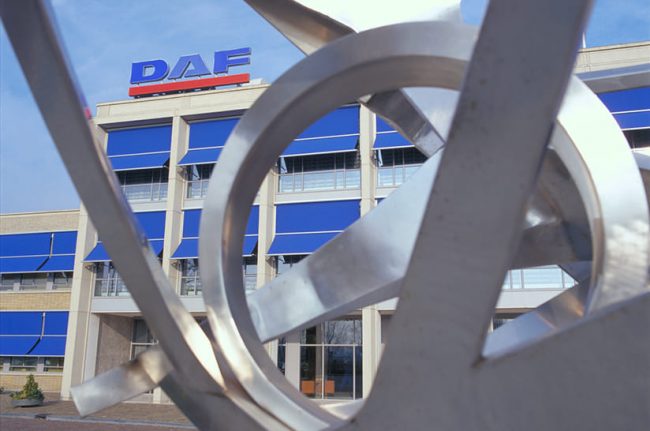 Das Bild zeigt den Firmensitz von DAF Trucks. Im Vordergrund sind Teile eines Kunstwerks zu sehen.