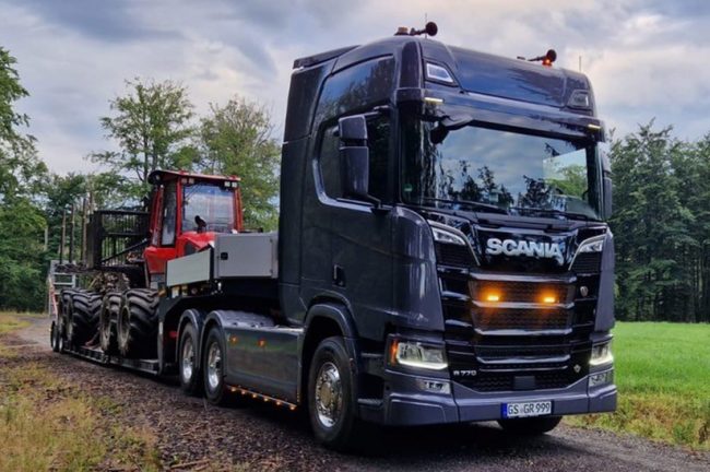 Das Bild zeigt einen Scania-LKW mit einem Anhänger von Doll Fahrzeugbau.