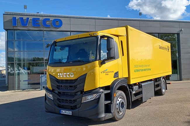 Das Foto zeigt einen gelb lackierten Iveco S-Way CNG der DHL Group.