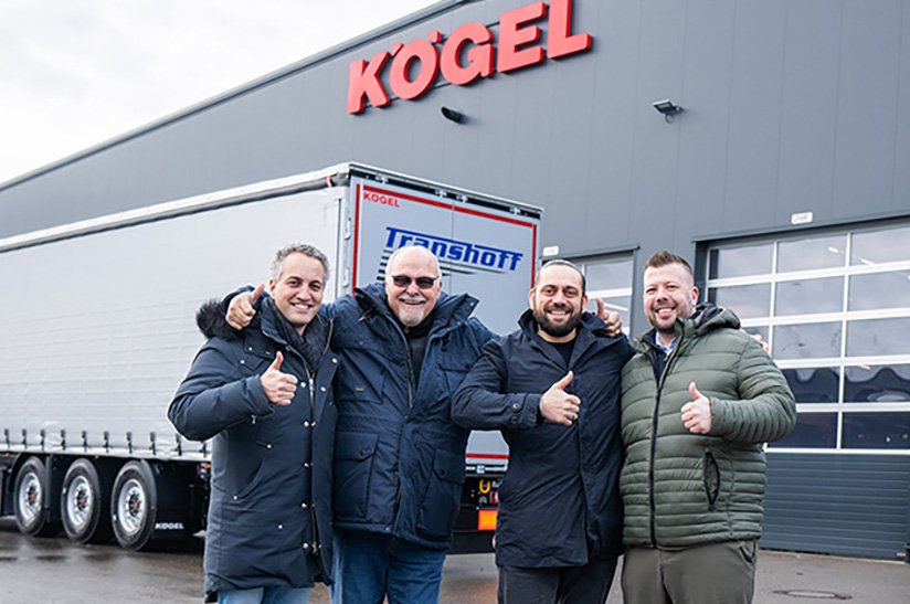 Kögel Transhoff Das Bild zeigt im Vordergrund vier Mitarbeiter der Unternehmen Kögel und Transhoff. Im Hintergrund sind zuerst ein LKW-Anhänger und dann eine Werkshalle zu sehen.