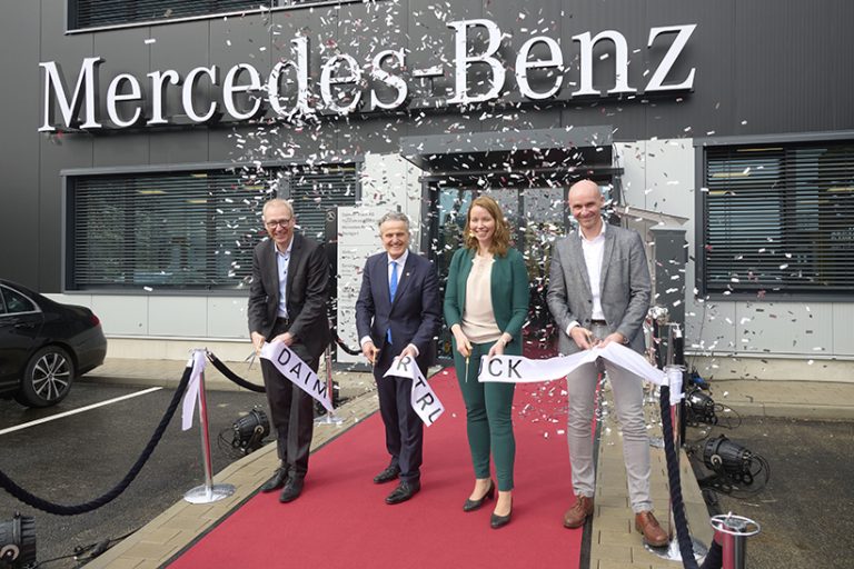 Das Foto zeigt drei Männer und eine Frau, die feierlich das symbolische Band bei der Eröffnung des neuen Nutzfahrzeugzentrums von Daimler Truck in Stuttgart durchtrennen.