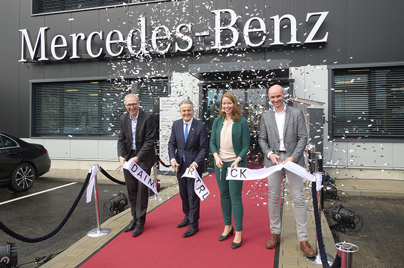 Das Foto zeigt drei Männer und eine Frau, die feierlich das symbolische Band bei der Eröffnung des neuen Nutzfahrzeugzentrums von Daimler Truck in Stuttgart durchtrennen.