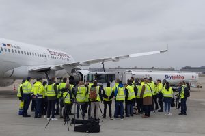 Das Bild zeigt eine Gruppe von Menschen mit gelben Westen auf dem Flugfeld des Flughafens Stuttgart.