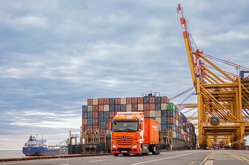 Logistiker Gebrüder Weiss verzeichnet 2,47 Milliarden Euro Nettoumsatz. Das Bild zeigt einen LKW, Container einen Kran und ein Schiff.