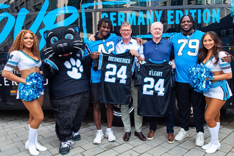 Spieler und Cheerleader der Carolina Panthers mit Mitarbeitern von Daimler Truck.