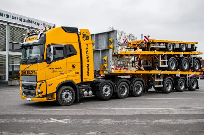 Das Bild zeigt einen gelben Truck mit drei aufeinander stehenden Trailern, die ES-GE für Franz Bracht aufbereitet hat.