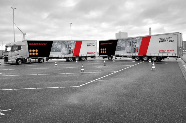 Das Bild zeigt einen Truck einen Trailer mit Aufdrucken von Kässbohrer.