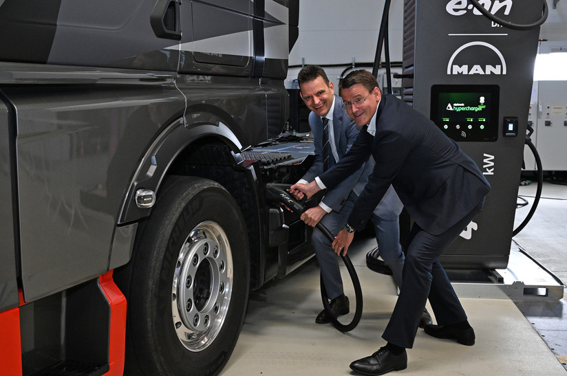 Führungskräfte von Eon und Man simulieren das Elektroladen eines Elektro-Lkw.