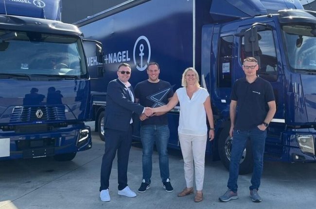Personal von Kühne+Nagel sowie Renault Trucks vor zwei blauen LKW.