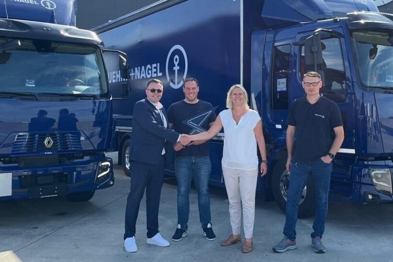 Personal von Kühne+Nagel sowie Renault Trucks vor zwei blauen LKW.