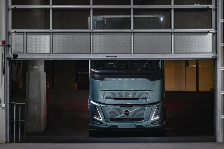 Das Bild zeigt einen Volvo FH Electric, der innerhalb einer Halle vor einem halbgeöffneten Tor steht.